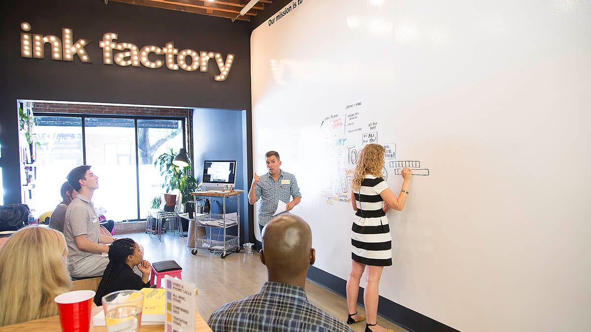 Dusty from Ink Factory demonstrates drawing on the dry-erase board during the workshop