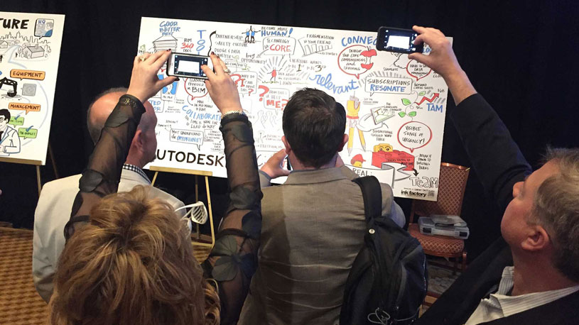 Attendees of a conference taking photos of a finished visual notes board