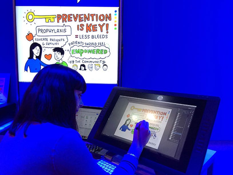 Artist drawing on Cintiq with projection next to them in blue lighting