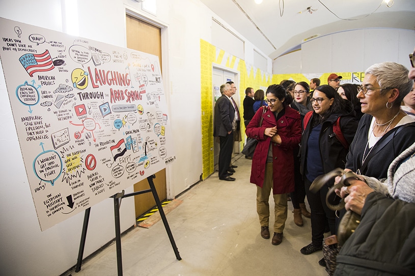 Audience members look at a graphic recording created at a Chicago Ideas event