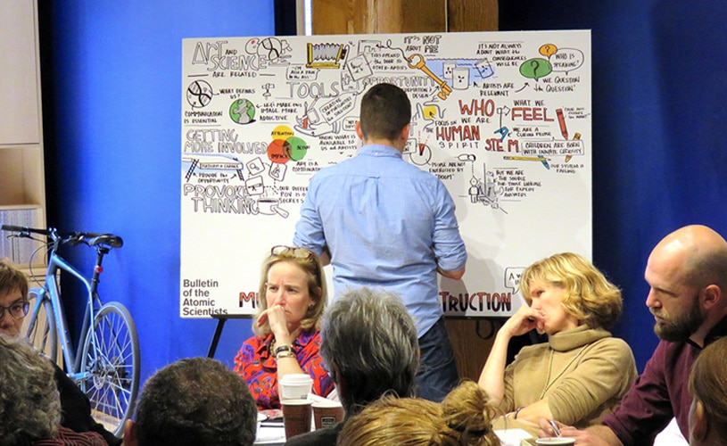 An artist creates visual notes live during an internal meeting for the Bulletin of Atomic Scientists