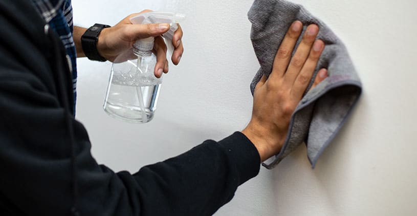 Erasing whiteboard ideas with a cloth and spray bottle