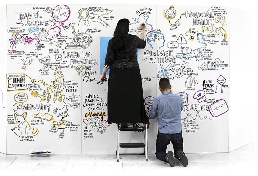 Two artists create live visual notes on a large mural