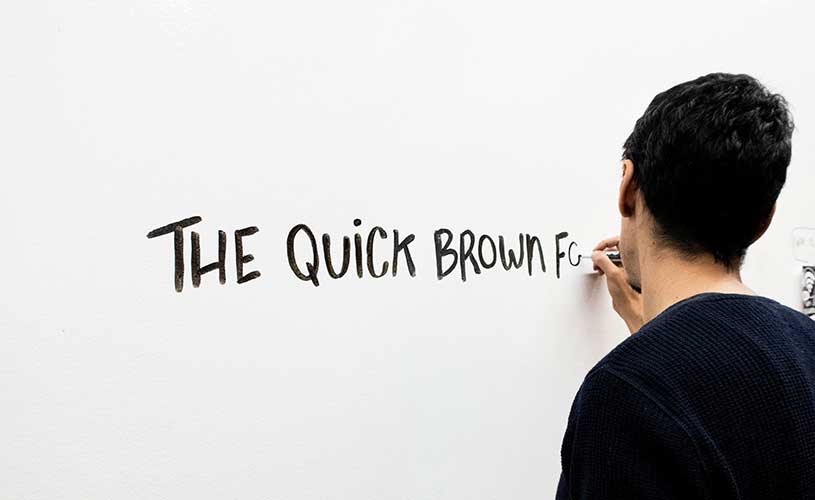 Artist practices text for dry erase drawings