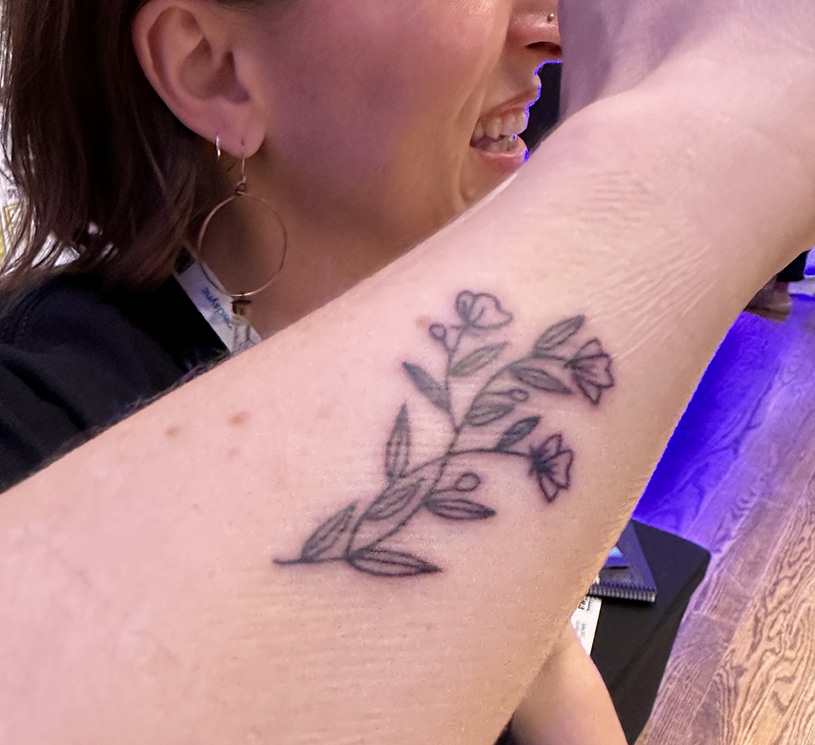 Ink Factory team member Teresa shows off her new tattoo from the event planner expo